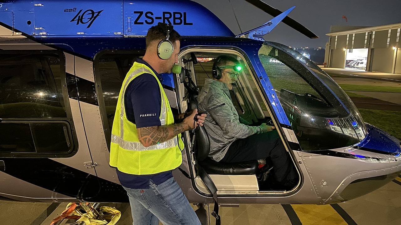 Bell 407 ZS-RLO doing an LED banner lift from Ultimate Heliport, Midrand