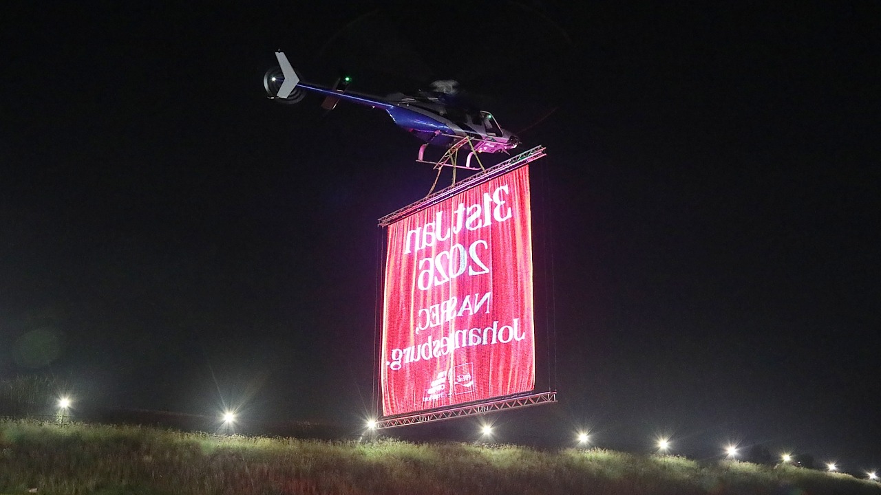 Bell 407 ZS-RLO doing an LED banner lift from Ultimate Heliport, Midrand